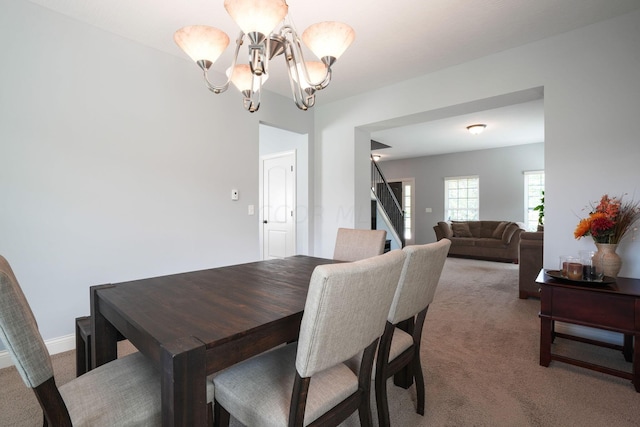 dining space featuring carpet flooring and a notable chandelier