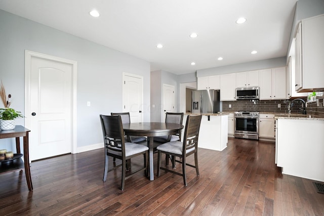 dining space with dark hardwood / wood-style flooring and sink