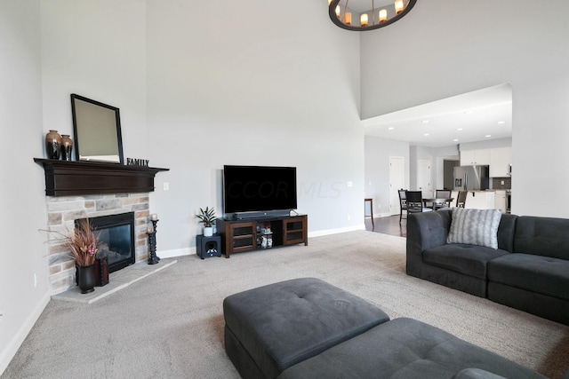 carpeted living room with a high ceiling and a fireplace