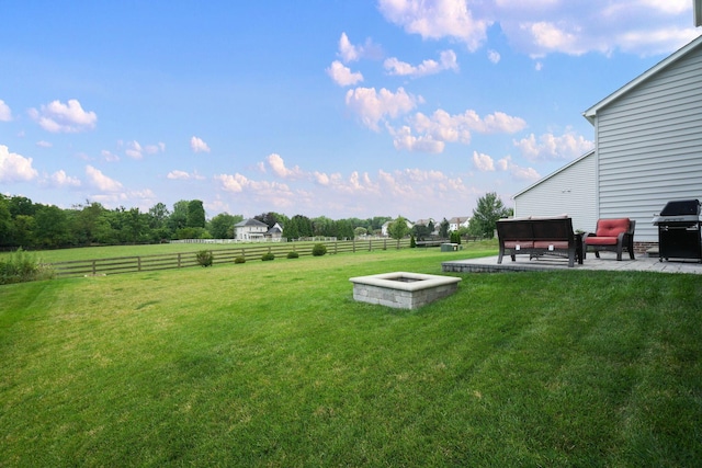 view of yard featuring a patio area, an outdoor fire pit, and a rural view