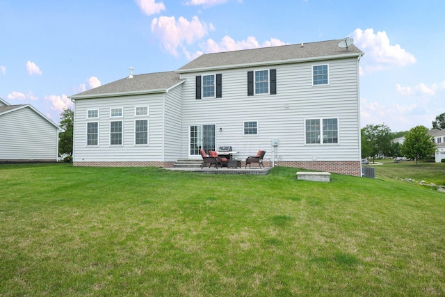 rear view of house featuring cooling unit, a lawn, and a patio