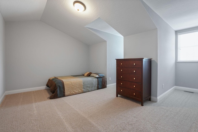 carpeted bedroom featuring lofted ceiling