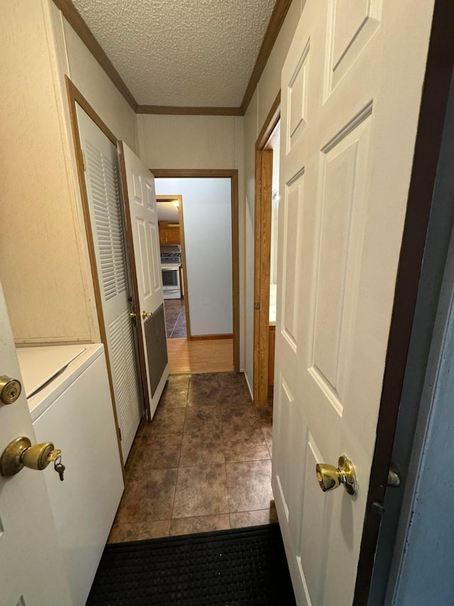 hall with crown molding, dark tile patterned flooring, and a textured ceiling