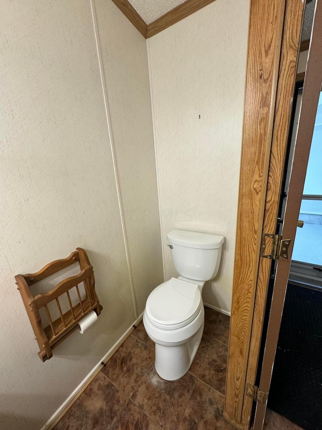 bathroom featuring tile patterned flooring, toilet, and crown molding