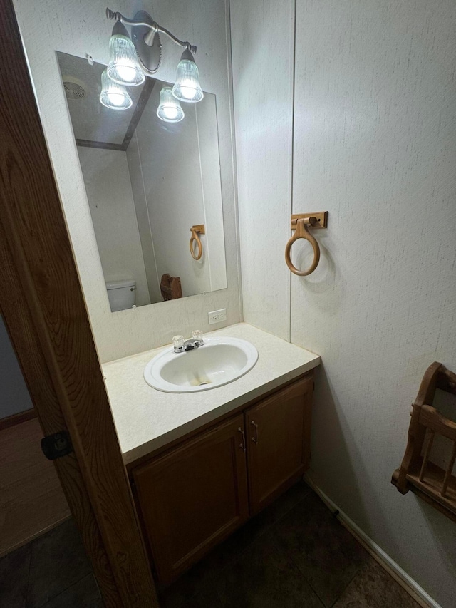 bathroom with toilet, vanity, and tile patterned floors