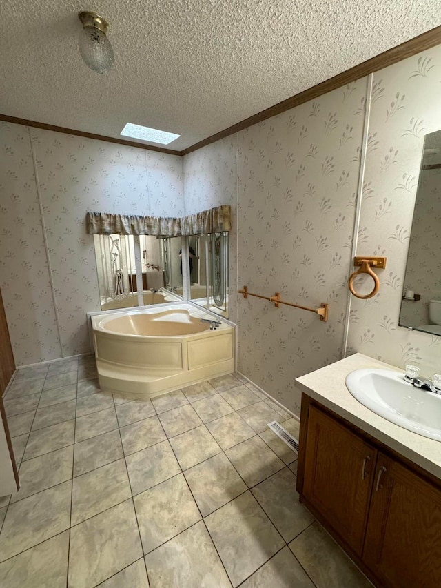 bathroom featuring a skylight, a bathing tub, tile patterned flooring, crown molding, and a textured ceiling