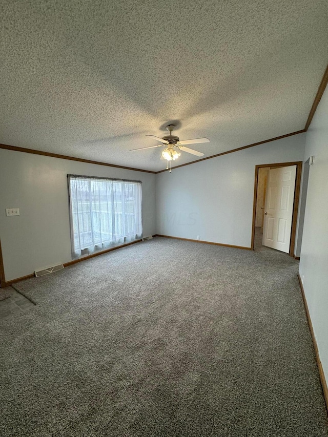 carpeted spare room featuring ceiling fan, ornamental molding, and a textured ceiling