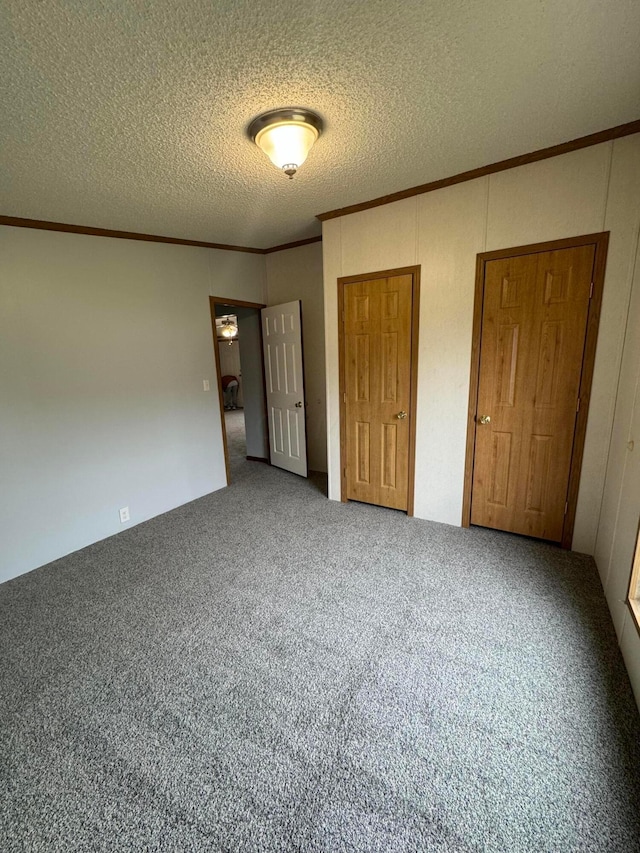 unfurnished bedroom featuring carpet flooring, a textured ceiling, and crown molding