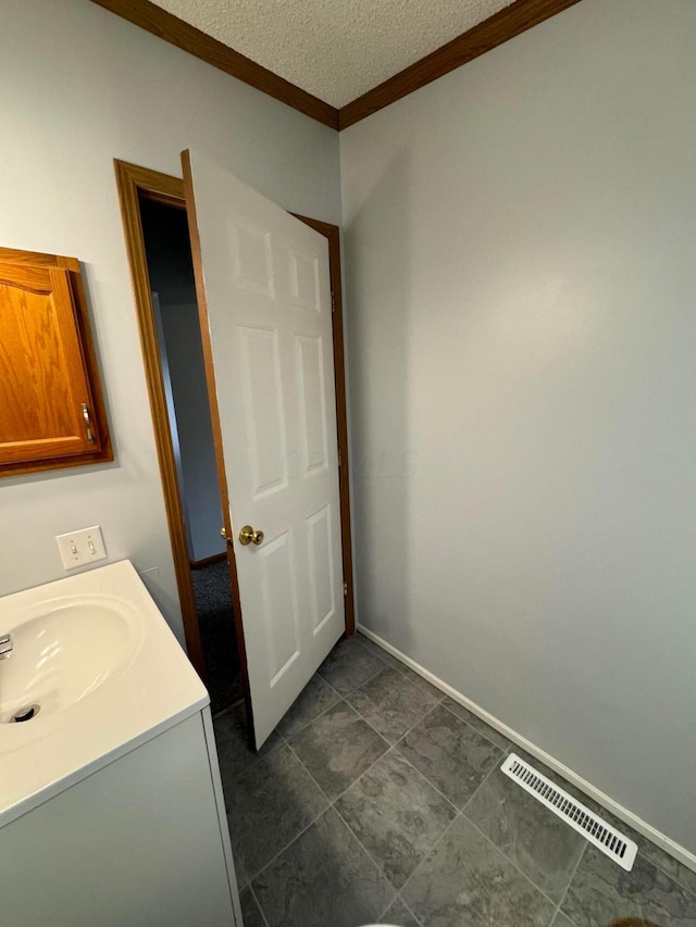 bathroom featuring vanity, a textured ceiling, tile patterned floors, and ornamental molding