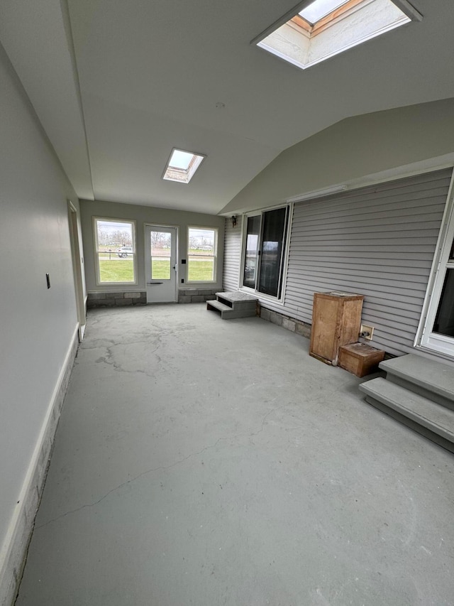 unfurnished sunroom featuring lofted ceiling with skylight