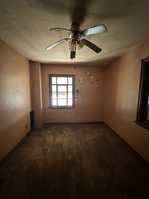 spare room featuring ceiling fan and dark wood-type flooring