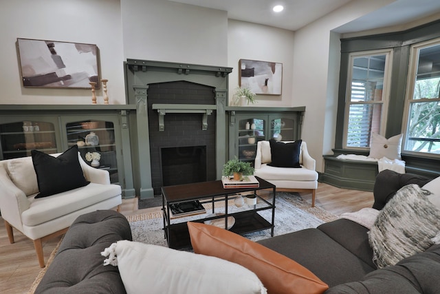 living room with light hardwood / wood-style floors and a brick fireplace