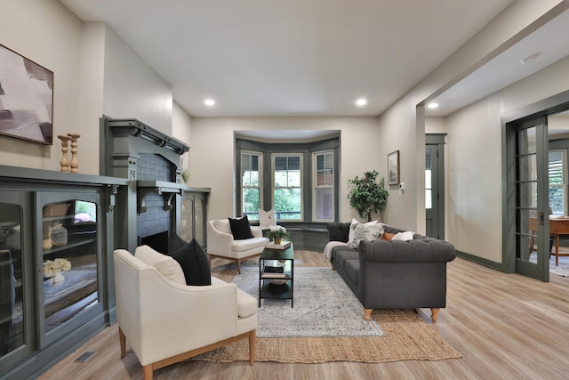 living room with a healthy amount of sunlight, french doors, and light hardwood / wood-style flooring