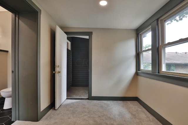 unfurnished bedroom with connected bathroom, a closet, and light colored carpet