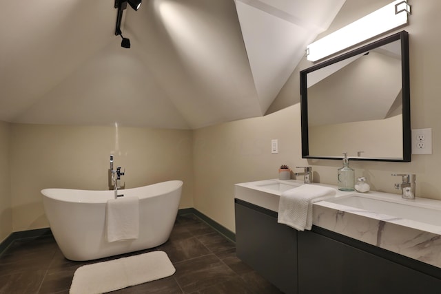 bathroom featuring a bathing tub, vanity, and lofted ceiling