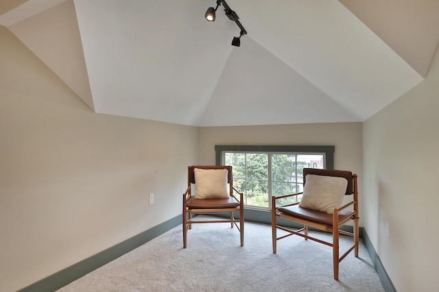 living area featuring rail lighting, light carpet, and vaulted ceiling