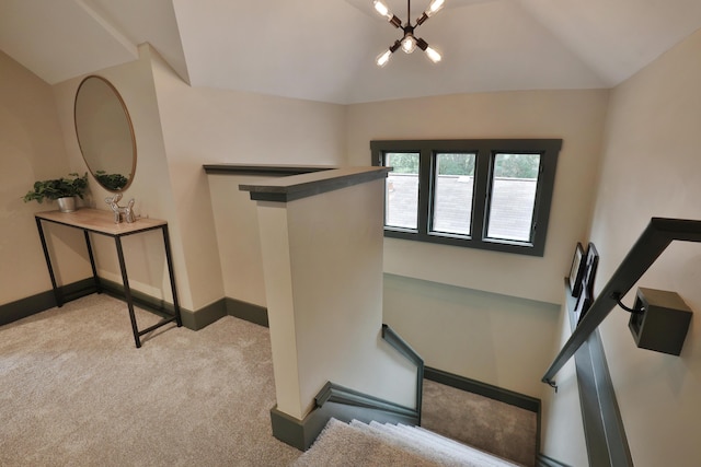 staircase with carpet flooring, a chandelier, and lofted ceiling