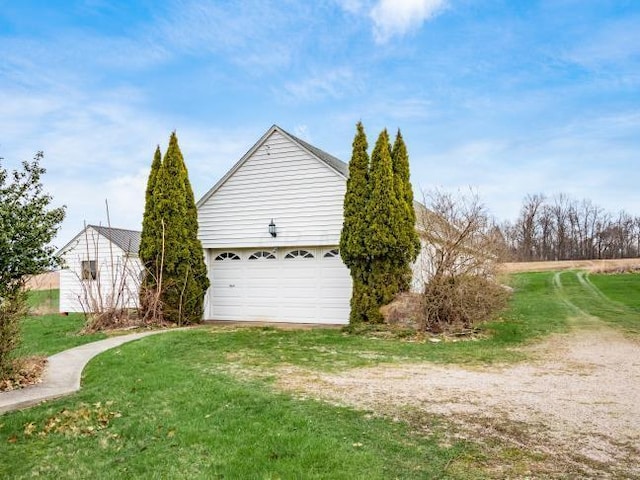 view of side of home featuring a lawn and a garage