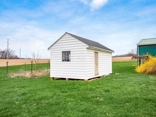 view of outbuilding featuring a yard and a rural view