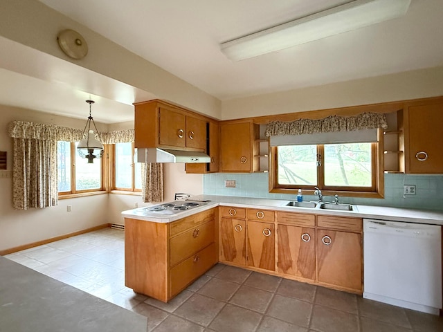 kitchen featuring light countertops, electric stovetop, under cabinet range hood, a sink, and dishwasher