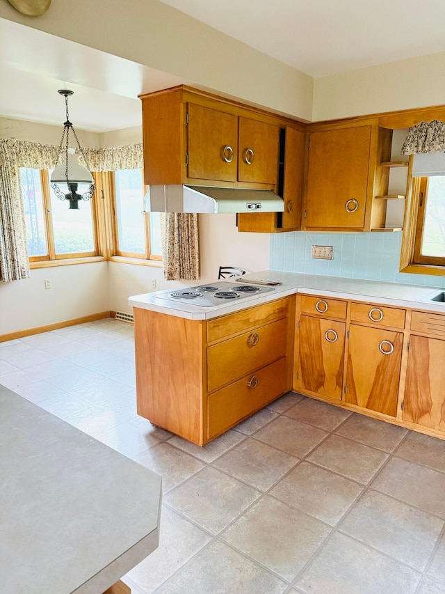 kitchen with open shelves, electric cooktop, light countertops, under cabinet range hood, and brown cabinets