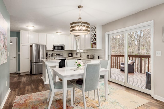 dining space featuring dark hardwood / wood-style floors, a notable chandelier, and sink