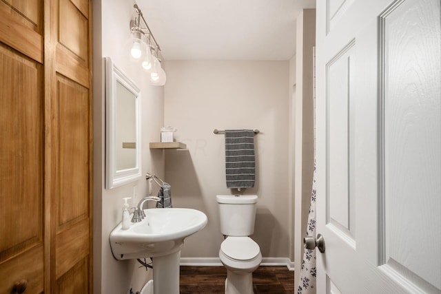 bathroom with hardwood / wood-style flooring and toilet