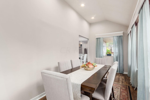 dining area featuring dark wood-type flooring and lofted ceiling