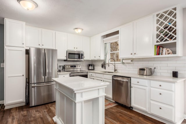 kitchen featuring sink, a center island, dark hardwood / wood-style floors, white cabinets, and appliances with stainless steel finishes