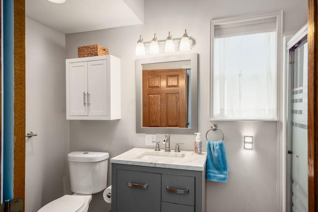 bathroom with a textured ceiling, vanity, and toilet