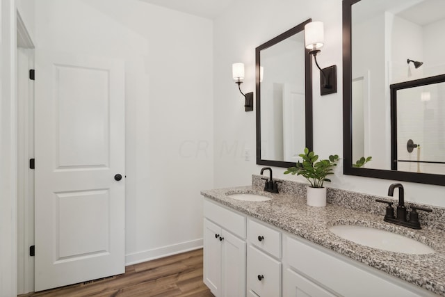 bathroom featuring hardwood / wood-style flooring, vanity, and a shower with door