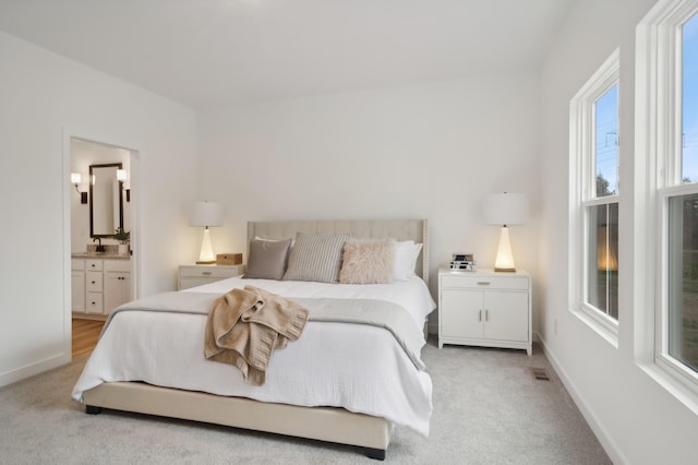 carpeted bedroom featuring connected bathroom