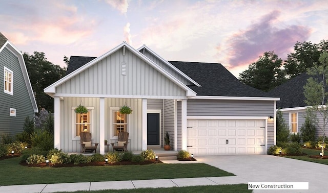 view of front of property featuring a porch, a yard, and a garage