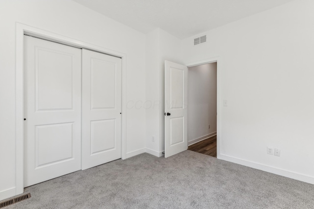 unfurnished bedroom featuring carpet and a closet