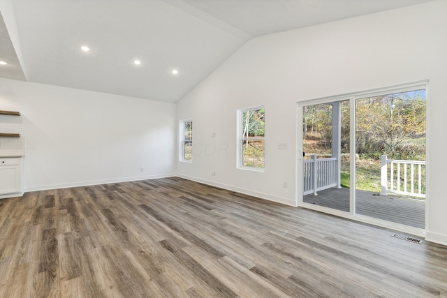 unfurnished living room featuring high vaulted ceiling and light hardwood / wood-style flooring