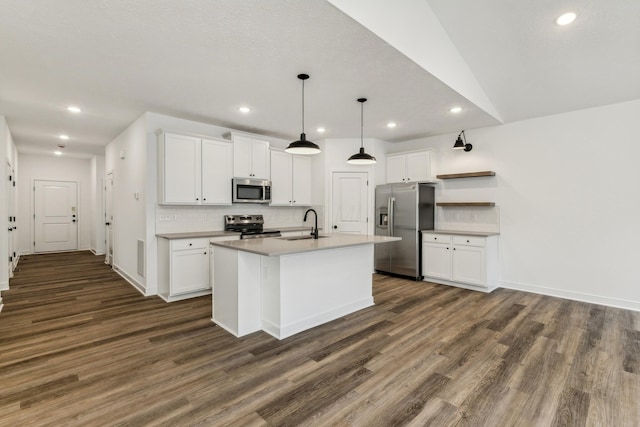 kitchen featuring stainless steel appliances, dark wood-type flooring, pendant lighting, a center island with sink, and white cabinets