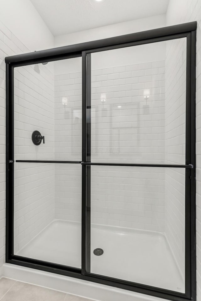 bathroom with tile patterned floors and a shower with shower door