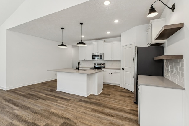 kitchen with dark hardwood / wood-style flooring, a center island with sink, white cabinets, and appliances with stainless steel finishes