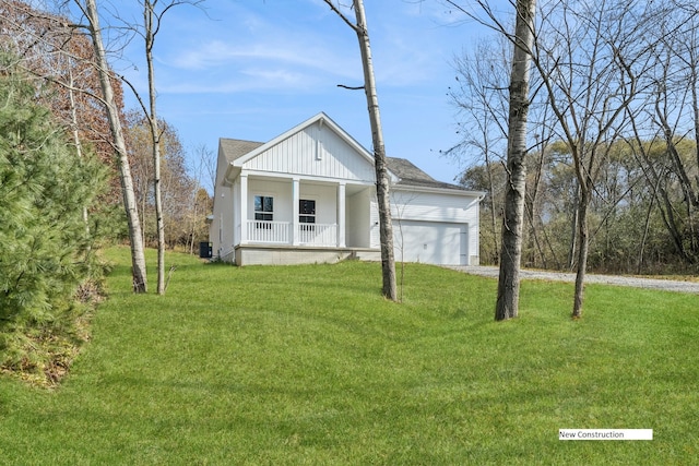 view of front of house with a porch, a garage, and a front lawn