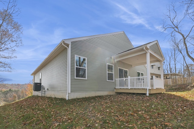 rear view of house featuring central AC unit and a deck