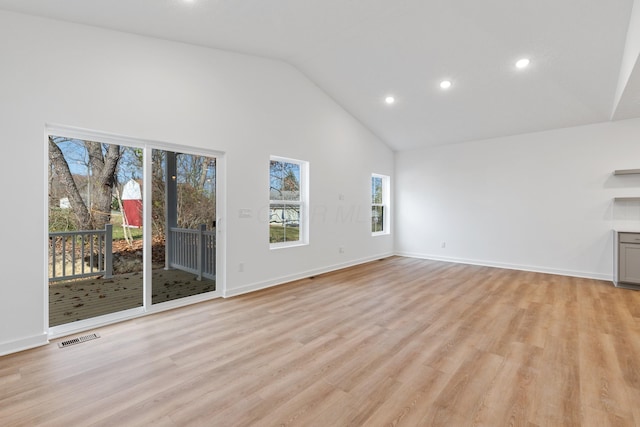 unfurnished living room featuring high vaulted ceiling and light hardwood / wood-style flooring