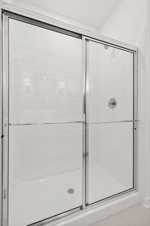 bathroom featuring tile patterned floors and a shower with door