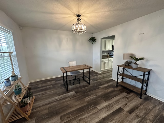 dining area featuring a textured ceiling, dark hardwood / wood-style floors, and an inviting chandelier