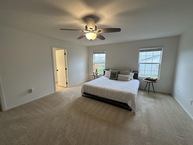 carpeted bedroom with ceiling fan and a textured ceiling