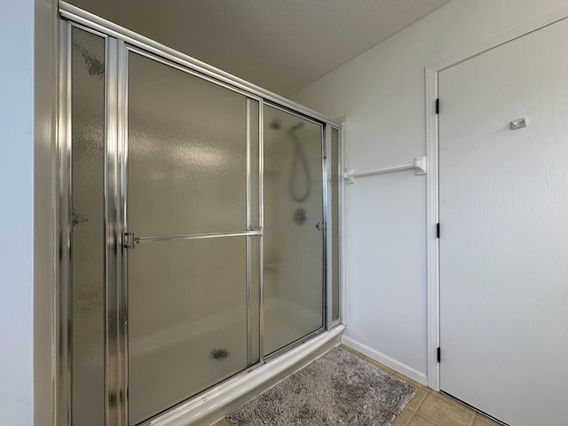 bathroom featuring tile patterned floors and a shower with shower door