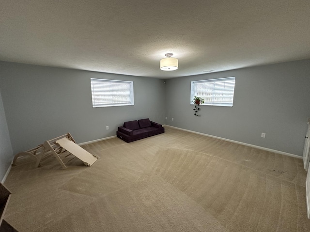 unfurnished room featuring a textured ceiling and light carpet