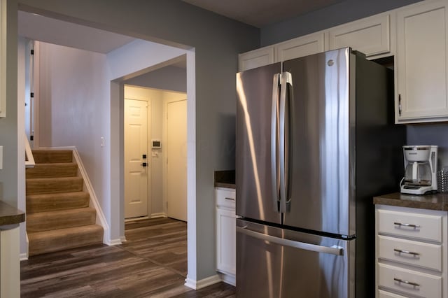 kitchen featuring dark hardwood / wood-style floors, stainless steel fridge, and white cabinetry