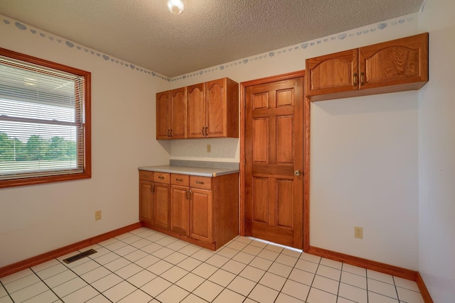 kitchen with light tile patterned floors and a textured ceiling