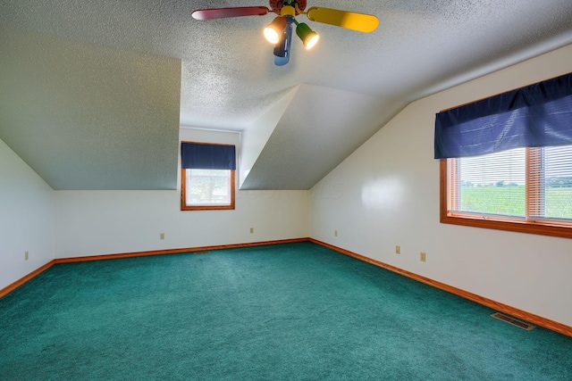 bonus room with vaulted ceiling, a wealth of natural light, carpet, and a textured ceiling