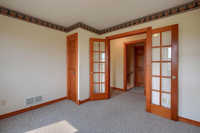 carpeted spare room with french doors